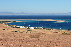 Golden sand beach and calm glistening waters of Dahab's crescent-shaped lagoon area, Egypt
